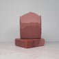 Two stacked bars of brown soap on a light gray background